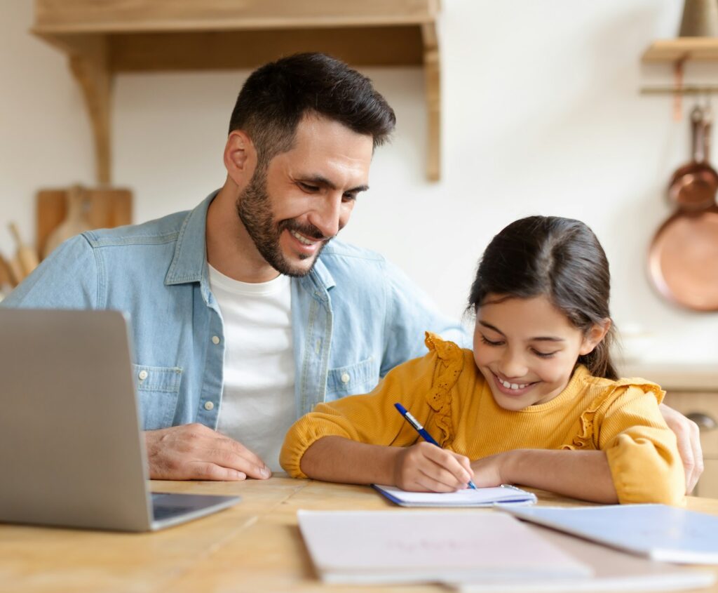 Man helping young girl with homework at home